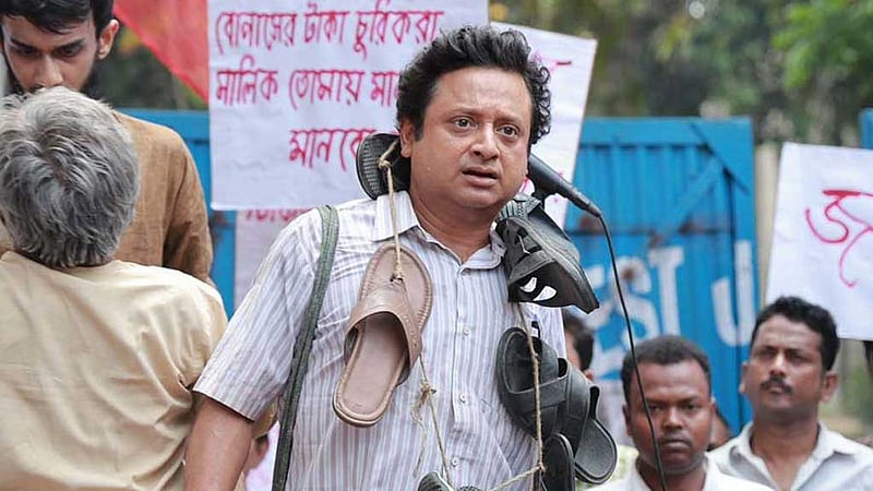 গলায় জুতোর মালা পরে মঞ্চে কী করছেন শিবপ্রসাদ?