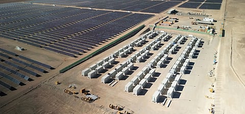 Technicians inspect utility-scale battery energy storage system containers connected to power conversion equipment, representing Nextpower's acquisition of Prevalon Energy to expand integrated grid-scale energy storage and power management capabilities.
