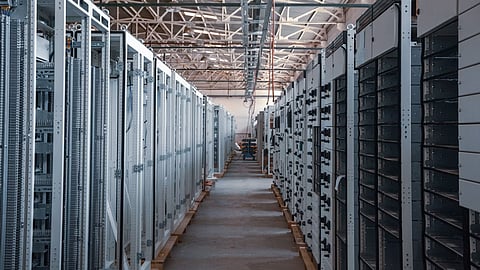 Illustration of standalone battery energy storage containers connected to a renewable-powered electricity grid, representing the European Commission's €59 million State aid programme supporting at least 370 MWh of battery storage deployment in Slovenia.