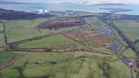 Aerial view of green fields and a coastal power station near Hunterston.
