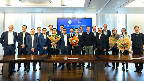 Around twenty people in suits stand with bouquets before a GIGA Storage and CATL screen.
