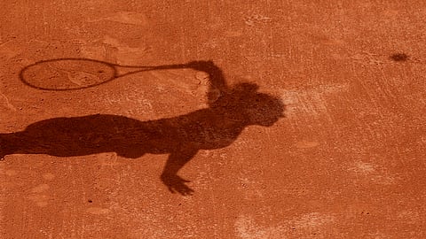 FILE - In this Tuesday, May 30, 2017 file photo a tennis player casts a shadow on the clay as they serve during a tennis match at the French Open tennis tournament at the Roland Garros stadium in Paris. Four people are in French custody on suspicion of fixing matches for an Armenian based in Belgium believed behind an illegal gambling syndicate suspected of fixing hundreds of matches. (AP Photo/Petr David Josek, File)