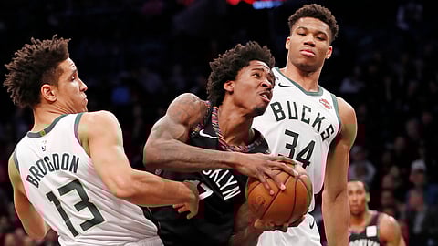 Milwaukee Bucks guard Malcolm Brogdon (13) and Bucks forward Giannis Antetokounmpo (34) double-team Brooklyn Nets forward Ed Davis (17) who gets sandwiched driving to the basket during the first half of an NBA basketball game, Monday, Feb. 4, 2019, in New York. (AP Photo/Kathy Willens)