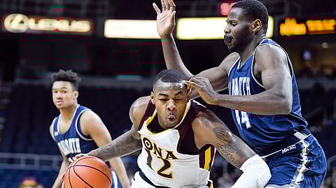 Iona forward Tajuan Agee dribbles  against Monmouth center Sam Ibiezugbe on March 11 (Hans Pennink)