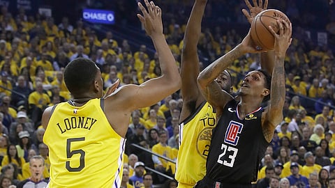 Los Angeles Clippers guard Lou Williams (23) shoots against Golden State Warriors center Kevon Looney (5) and forward Draymond Green during the  NBA basketball playoff series on Monday, April 15, 2019.