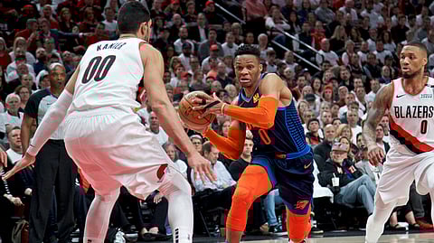 Oklahoma City Thunder guard Russell Westbrook, center, drives to the basket past Portland Trail Blazers guard Damian Lillard, right, and center Enes Kanter, left, during Game 5 of an NBA basketball first-round playoff series on April 23, 2019.