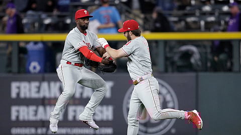 Philadelphia Phillies right fielder Bryce Harper, right, dunks his glove into the arms of Phillies center fielder Andrew McCutchen after beating the Colorado Rockies on April 20, 2019.&nbsp;
