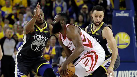 Houston Rockets’ James Harden, center, is defended by Golden State Warriors’ Andre Iguodala, left, and Stephen Curry in Game 2 of a second-round NBAplayoff series in Oakland, Tuesday, April 30, 2019. (AP Photo/Jeff Chiu)