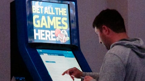 This June 21, 2019 photo shows a gambler making bets at a William Hill kiosk inside the Ocean Casino Resort in Atlantic City, N.J.