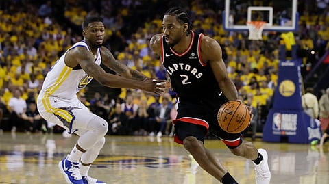 Toronto Raptors forward Kawhi Leonard (2) dribbles against Golden State Warriors forward Alfonzo McKinnie during the first half of Game 3 of basketball’s NBA Finals in Oakland, Calif., Wednesday, June 5, 2019. (AP Photo/Ben Margot)