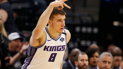 Sacramento Kings guard Bogdan Bogdanovic flashes three fingers after scoring a 3-point basket during the first quarter of the team's NBA basketball game against the Washington Wizards in Sacramento, Calif., Tuesday, March 3, 2020. (AP Photo/Rich Pedroncelli)