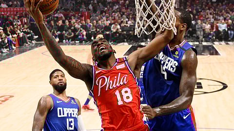 Philadelphia 76ers guard Shake Milton, center, shoots as Los Angeles Clippers forward JaMychal Green, right, defends and guard Paul George watches during the first half of an NBA basketball game Sunday, March 1, 2020, in Los Angeles. (AP Photo/Mark J. Terrill)