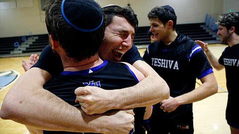 Yeshiva forward Michael Bixon hugs forward Daniel Katz, back to camera, after the team's 102-83 win over Penn State-Harrisburg in the second round of the NCAA men's Division III college basketball tournament Saturday, March 7, 2020, in Baltimore. (AP Photo/Jessie Wardarski)
