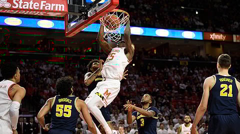 Maryland forward Jalen Smith (25) dunks against Michigan guard Eli Brooks (55), guard Zavier Simpson (3) and forward Isaiah Livers, back, during the second half of an NCAA college basketball game, Sunday, March 8, 2020, in College Park, Md.