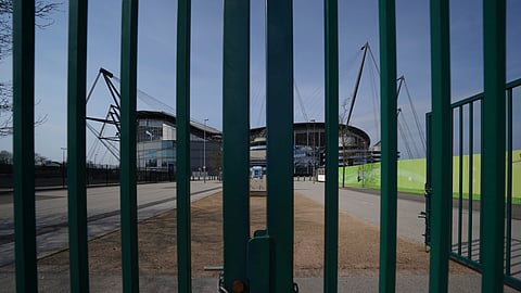 Gates stand locked outside the closed Manchester City Etihad Stadium, in Manchester, northern England, as the English Premier League soccer season has been suspended due to coronavirus, Thursday, April 9, 2020. 