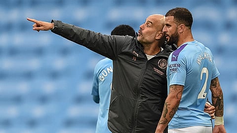 Manchester City's head coach Pep Guardiola, left, talks with Manchester City's Kyle Walker during the English Premier League soccer match between Manchester City and Newcastle at the Ethiad Stadium in Manchester, England, Wednesday, July 8, 2020. (Oli Scarff/Pool via AP)
