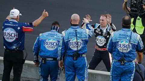 Kevin Harvick, on far side of wall, celebrates with his crew after winning the NASCAR Cup Series auto race at Indianapolis Motor Speedway in Indianapolis, Sunday, July 5, 2020. (AP Photo/Darron Cummings)