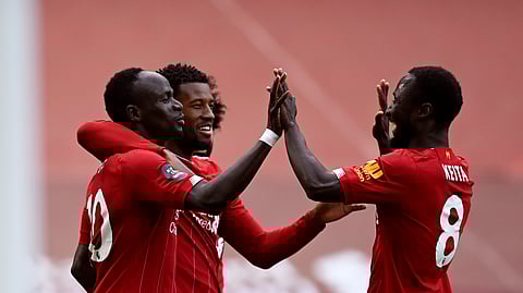 Liverpool's Sadio Mane, left, celebrates after scoring the opening goal during the English Premier League soccer match between Liverpool and Aston Villa at Anfield Stadium in Liverpool, England, Sunday, July 5, 2020.