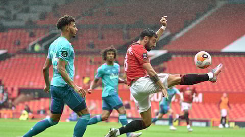 Manchester United's Bruno Fernandes, right, reaches for the ball while Bournemouth's Lloyd Kelly, left, defends during the English Premier League soccer match between Manchester United and Bournemouth at Old Trafford stadium in Manchester, England, Saturday, July 4, 2020.