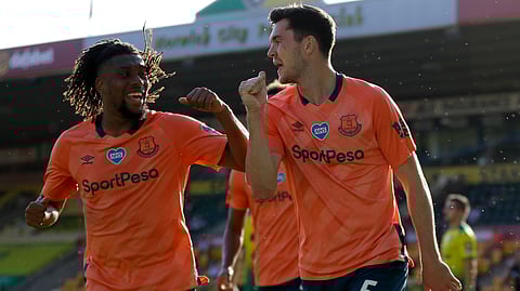 Everton's Michael Keane, right, and Everton's Alex Iwobi celebrate scoring their side's first goal during the English Premier League soccer match between Norwich and Everton at Carrow Road Stadium in Norwich, England, Wednesday, June 24, 2020. 