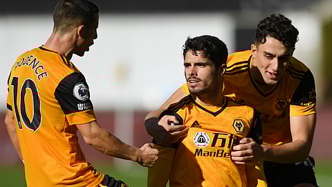 Wolverhampton Wanderers' Pedro Neto, centre celebrates with team mates after scoring his side's opening goal during an English Premier League soccer match between Wolverhampton Wanderers and Fulham at the Molineux Stadium in Wolverhampton, England, Sunday Oct. 4, 2020.