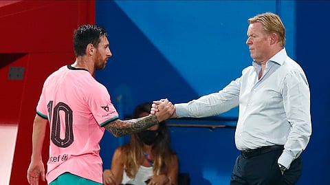 Barcelona's Lionel Messi, left, shakes hands as he is substituted with Barcelona's coach Ronald Koeman as he is substituted during the pre-season friendly soccer match between Barcelona and Girona at the Johan Cruyff Stadium in Barcelona, Spain, Wednesday, Sept. 16, 2020. 