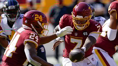 Washington Football Team quarterback Dwayne Haskins (7) hands the ball to Washington Football Team running back Antonio Gibson (24) against the Baltimore Ravens during the first half of an NFL football game, Sunday, Oct. 4, 2020, in Landover, Md.