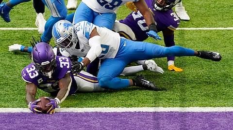 Minnesota Vikings running back Dalvin Cook (33) scores on a 5-yard touchdown run in front of Detroit Lions safety Duron Harmon (26) during the first half of an NFL football game, Sunday, Nov. 8, 2020, in Minneapolis. 