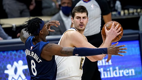 Denver Nuggets center Nikola Jokic, right, looks to pass the ball as Minnesota Timberwolves forward Jarred Vanderbilt defends during the first half of an NBA basketball game Tuesday, Jan. 5, 2021, in Denver. 