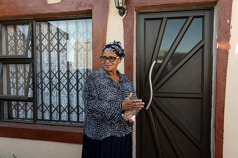 Nonkosi Klaas shows off the new door to her home that she bought with some of rental income earned from apartments built in her backyard in Langa, Cape Town.
