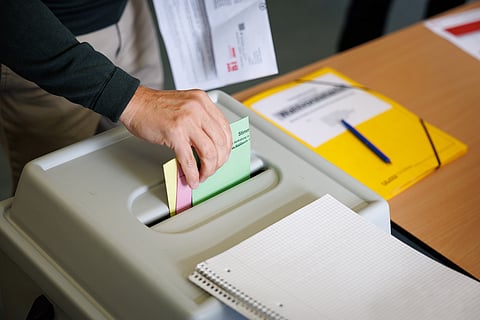 A voter casts a ballot at a polling station during the local elections in Bielefeld, North Rhine-Westphalia, Germany, on Sept. 14, 2025.