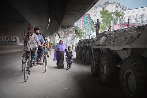 Bloomberg Best of the Year 2024: Pedestrians pass military tanks following protests in Dhaka, Bangladesh.