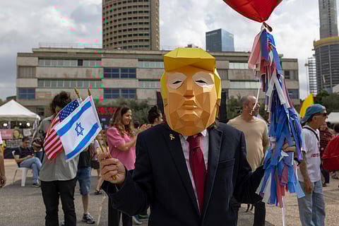 An Israeli wearing a 'Trump' mask celebrates after the announcement that Israel and Hamas have reached a deal for the release all hostages, in Tel Aviv, Israel, on Thursday, Oct. 9, 2025. The agreement was reached early on Thursday after several days of indirect negotiations between the warring sides in the Egyptian resort of Sharm El-Sheikh.