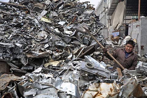 A worker shovels scrap metal onto the back of a truck near Wenzhou, China, on Tuesday, April 15, 2008. China imports bulk shipments of scrap metal from developed countries such as the United States and Japan. 