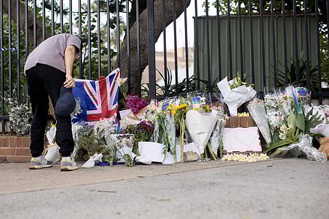 A mourner lays flowers near the scene of the mass shooting at Bondi Beach in Sydney, Australia, on Monday, Dec. 15, 2025. Sixteen people have been killed in Australia's worst terrorist attack after gunmen opened fire on Jewish people who had gathered to celebrate the first day of Hanukkah at Sydney's iconic Bondi Beach on Sunday evening.