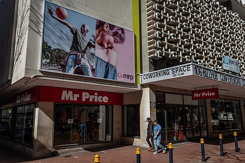 Pedestrians walk past a Mr Price Group Ltd.