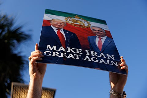 A counter-demonstrator holds a "Make Iran Great Again" sign across from a protest against war in Iran in Houston, Texas, US, on Saturday, Feb. 28, 2026.