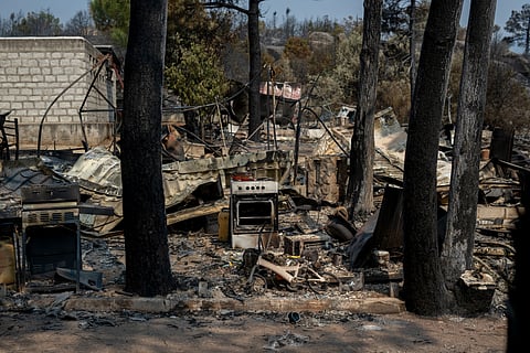 The remains of burned out caravans, ovens and leisure equipment at the Pantano de Burguillo campsite following a wildfire in El Barraco, Spain.