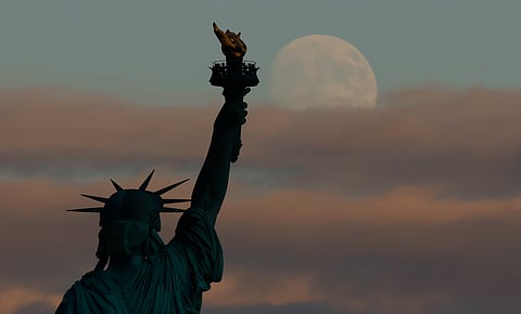 JERSEY CITY, NJ - AUGUST 25: A 95 percent illuminated Sturgeon Moon rises out of a cloud behind the Statue of Liberty in New York City, two nights before a lunar eclipse on August 25, 2026, as seen from Jersey City, New Jersey. (Photo by Gary Hershorn/Getty Images)