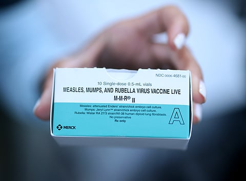 CORAL GABLES, FLORIDA - AUGUST 13: A Medical Assistant holds a box of measles, mumps and rubella, vaccine doses at the pediatric office of Dr. Gary M. Kramer on August 13, 2026, in Coral Gables, Florida. President Donald Trump signed an executive order on Monday to overhaul childhood vaccination policy. (Photo by Joe Raedle/Getty Images)