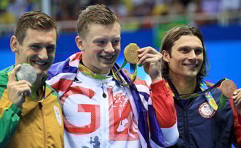 2016 Rio Olympics - Swimming - Victory Ceremony - Men's 100m Breaststroke Victory Ceremony - Olympic Aquatics Stadium - Rio de Janeiro, Brazil - 07/08/2016. Gold medallist Adam Peaty (GBR) of United Kingdom poses with silver medallist Cameron van der Burgh (RSA) of South Africa and bronze medallist Cody Miller (USA) of USA.     REUTERS/Dominic Ebenbichler