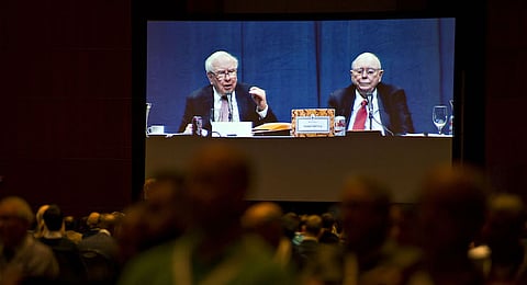Warren Buffett, chairman and chief executive officer of Berkshire Hathaway Inc., left, and Charlie Munger, vice chairman of Berkshire Hathaway, are seen on a video screen in an overflow room as they speak during the company's annual meeting in Omaha, Nebraska, U.S., on Saturday, May 6, 2017. Buffett said during the Berkshire investors gathering that he's more inclined than usual this year to sell some assets because the tax advantage could soon diminish for divesting securities at a loss. Photographer: Daniel Acker/Bloomberg