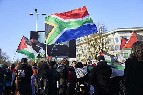 Protesters wave a South African national flag outside the ICJ on Jan. 26.