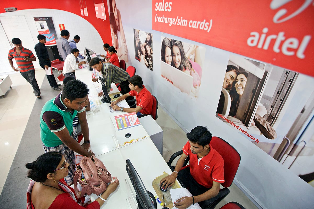 

Bharti Airtel Ltd. sales assistants serve customers at the company’s flagship store in Mumbai (Photographer: Kuni Takahashi/Bloomberg)