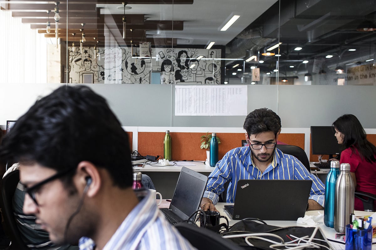 Employees working on their laptops in an office. (Photographer: Udit Kulshrestha/Bloomberg)