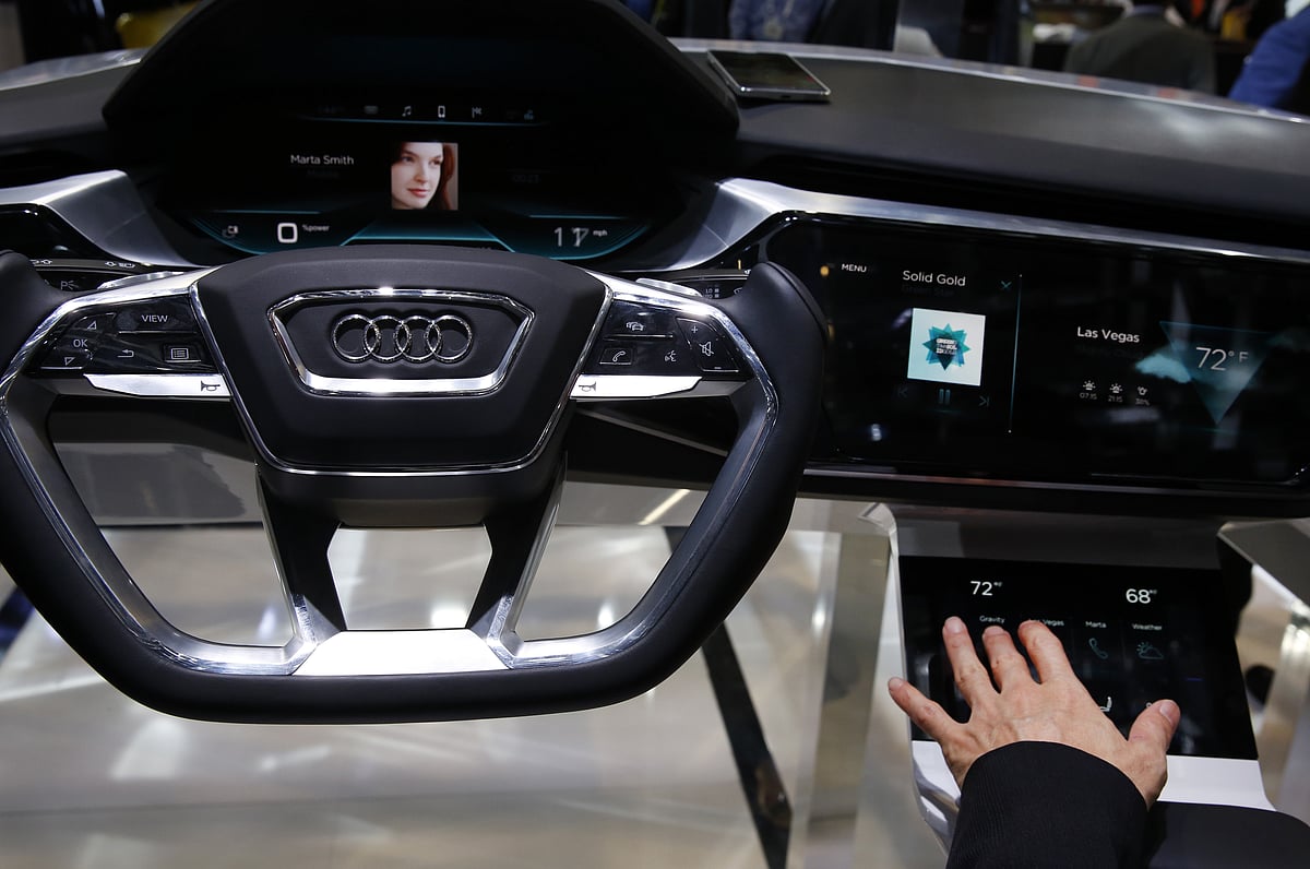 

An attendee demonstrates a car device at the car electronic show (Photographer: Patrick T. Fallon/Bloomberg)