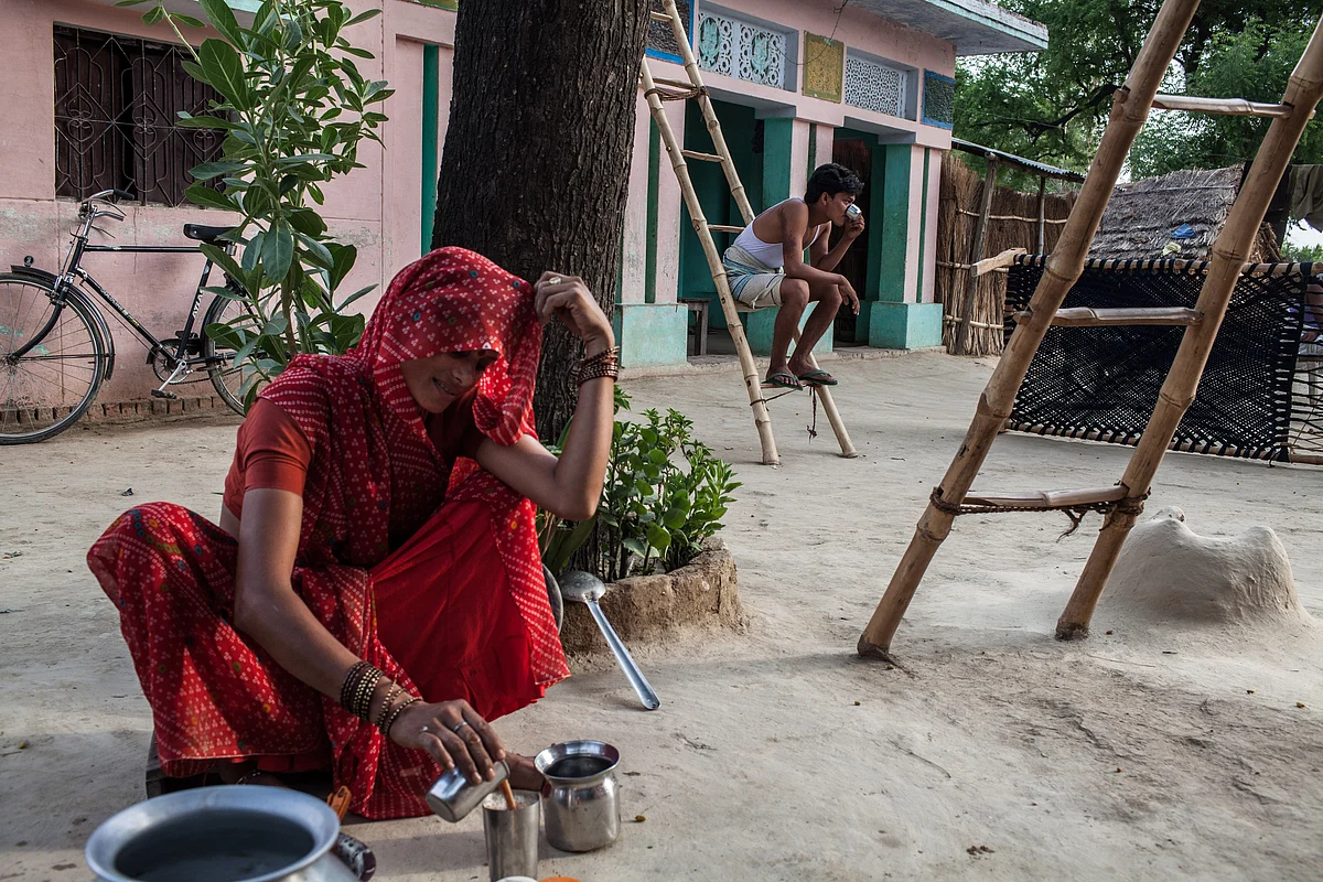 34-year-old Rajkumari Yadav prepares tea in an open kitchen in Auar Village in Pratapgarh district of Uttar Pradesh, India. (Photographer: Sanjit Das/Bloomberg)