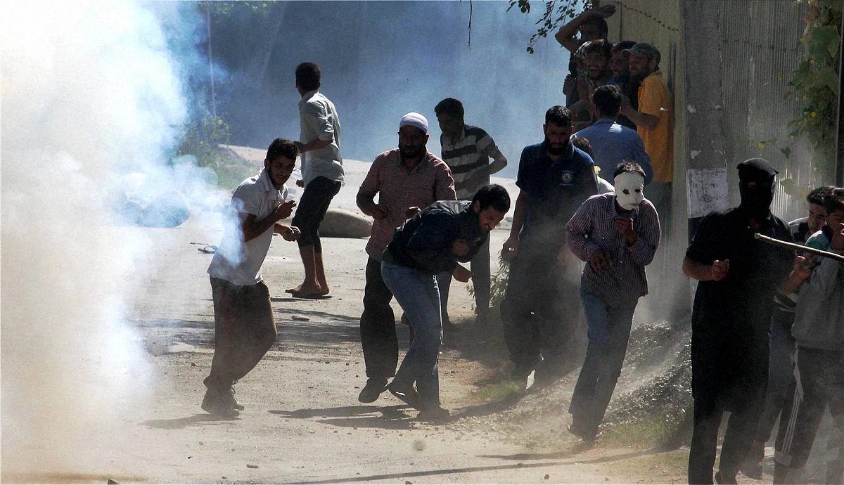 Youths throw stones on police during clashes between police and protesters, who were protesting against the killing of civilians, in Srinagar on Saturday. (Source: PTI)