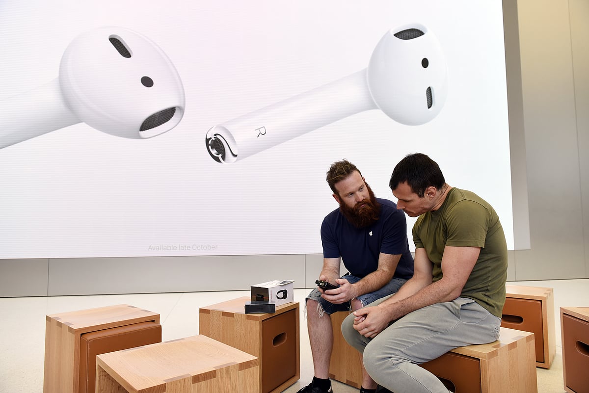 An employee, left, assists a customer with an iPhone 7 smartphone at an Apple Inc. in San Francisco, California. (Photographer: Michael Short/Bloomberg)