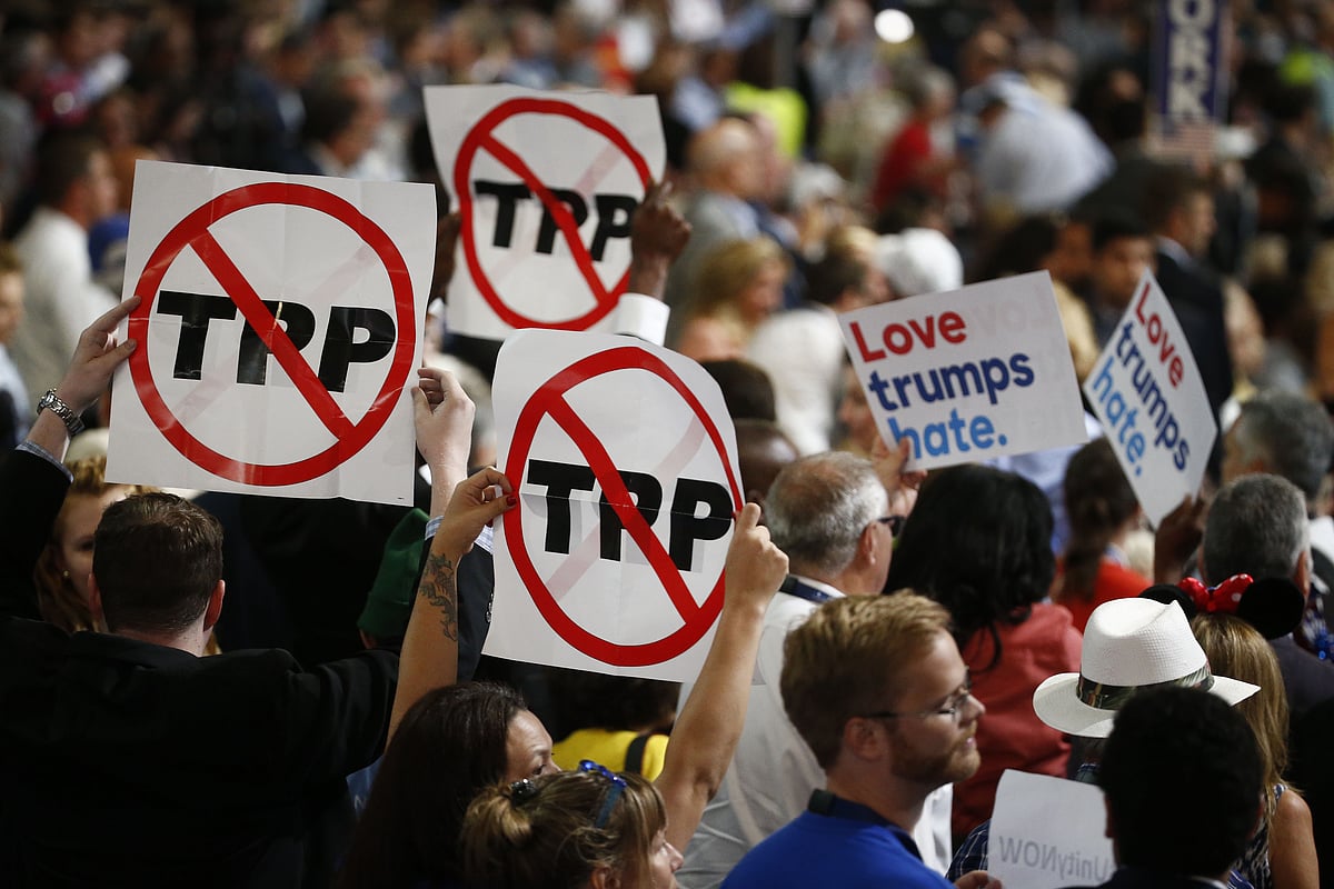 Delegates hold signs against the Trans-Pacific Partnership (TPP) during the Democratic National Convention. (Photographer: Andrew Harrer/Bloomberg)